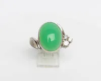 Ring, 14kt white gold, chrysoprase cabochon approx. 8.0 ct, three brilliants total approx. 0.30 ct, approx. 7.6 g, size 54