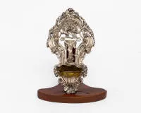 Bénitier, argent, 19e s., probablement travail d'Allemagne du Sud, cadre avec rocailles et feuillage débordant, au centre représentation plastique du corps du Christ sur la croix, couronné de trois putti, récipient fortement saillant en forme de coquille, intérieur doré, 26 cm de haut, 14 cm de large, env. 182 g