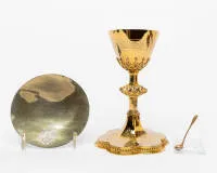 Neo-Gothic chalice with paten, August Wüsten, Cologne, early 20th c., silver gilt, six-lobed richly engraved foot with openwork tracery gallery and central cross motif, above it architecturally structured stem with strong...