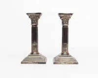 Paire de bougeoirs colonnes néoclassiques, Londres, 1963, argent sterling, douille à côtés rentrants dans chapiteau corinthien d'une colonne cannelée sur base étagée à profil carré, base lestée, H. 18,5 cm, env. 811 g