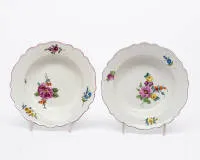 Deux assiettes à soupe, Meissen, marque aux épées, époque Marcolini, 1774 - 1814, aile contournée avec bord violet, peinture florale, ø 22,5 cm/23 cm, une légère fêlure de cuisson dans le bord, un éclat dans l'anneau de base
