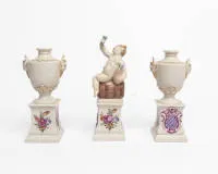 3 предмета белого фарфора, Nymphenburg, 2 маленькие амфоры-вазы с ручками-сатирами и маленький Вакх на бочонке на постаменте с картушем герба, ок. 15 см и 18.5 см высотой