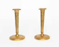 Ein Paar Empireleuchter / Kerzenständer, Frankreich, Anfang 19. Jh., Bronze vergoldet, fein ziseliertes Dekor, schlanker konischer Schaft über rundem Stand, H. 19 cm