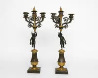 Ein Paar figürliche Girandolen / Kerzenleuchter, Empire, Frankreich, 1. Hälfte 19. Jh., Bronze teils vergoldet, je dreiflammig, im Schaft je eine dunkel patinierte Skulptur der geflügelten Siegesgöttin Victoria mit Lorbeerkranz, H. 56 cm