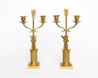 Pair of candelabra / candlesticks, France, Empire, circa 1800, fire-gilt bronze, two-light, shaft shaped as arrow held by seated putti, h. 36.5 cm