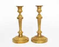 Paire de bougeoirs classiques, Louis XVI, France, vers 1780, bronze doré au feu, douille sur fût conique sur base ronde, H. 27 cm.