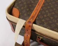 Vintagekoffer Louis Vuitton, Modell Stratos 70, Frankreich, 20. Jh., monogrammiertes dunkelbraunes Leder, hellbrauner Lederbesatz an den gerundeten Ecken, zwei Gürtelschließen und ein umlaufender Reißverschluss auf der Lasche geprägt "LV", unterseitig...