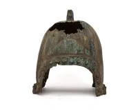 Bronze helmet, probably China or North Chinese-Inner Asian cultural area, possibly Zhou to Han period, 1st millennium BC to 1st millennium AD, copper alloy, probably bronze, cast; tall, almost hemispherical helmet bell with pronounced radial ribs and solid rectangular openwork top ornament, probably to hold a formerly present helmet decoration; in the lower area, arched fields on both sides and a circumferential row of large round bosses; on the lower edge, several sturdy rectangular eyelets, pr