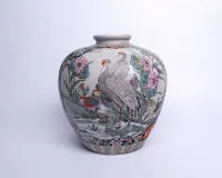 Vase, China, 20th c., porcelain, bulbous form, famille rose, two reserves with birds by water or on rocks, ground covered with flowers, borders, round iron-red mark on the base, 33 cm high