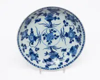 Grande coupe, Chine, dynastie Qing, probablement époque Qianlong (1736-1795) ou plus tard dans le style Qianlong, porcelaine bleu sous couverte, médaillon floral au centre, l'aile avec chrysanthèmes, pivoines et branches fleuries en disposition symétrique,...