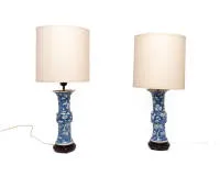 Paire de vases chinois en lampes de table, style Kangxi, vers 1900, décor bleu et blanc de prunus et fleurs de prunier, abat-jour clairs, socles en bois sculpté, H. 25,5 cm hors montage et socle, un vase avec cassure agrafée et éclat