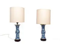Paire de vases chinois en lampes de table, style Kangxi, vers 1900, décor bleu et blanc de prunus et fleurs de prunier, abat-jour clairs, socles en bois sculpté, H. 25,5 cm hors montage et socle, un vase avec cassure agrafée et éclat
