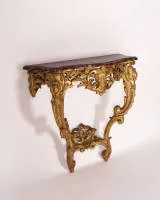 Trompe-l'oeil console, Rococo, probably Italy, mid-18th century, frame in wood richly openwork carved and gilded over red ground, the profiled and curved top in wood, artfully marbled and painted, 85.5 x 88 x 40 cm, restored