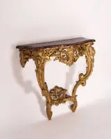 Trompe-l'oeil console, rococo, waarschijnlijk Italië, midden 18e eeuw, frame van hout rijk opengewerkt gesneden en verguld op rode grond, het geprofileerde en gebogen blad van hout, kunstig gemarmerd en beschilderd, 85.5 x 88 x 40 cm, gerestaureerd
