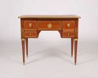 Neoclassical desk, Louis XVI, France, circa 1780, stamped under the front apron "J. CAUMONT / JME", mahogany veneer, rich partly gilded mounts, body with five drawers under projecting top on tapered fluted...