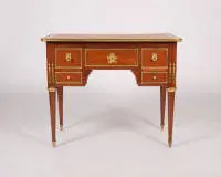 Bureau classique, Louis XVI, France, vers 1780, estampillé sous la ceinture avant "J. CAUMONT / JME", placage d'acajou, riches garnitures partiellement dorées, corps à cinq tiroirs sous plateau en saillie sur pieds fuselés cannelés...