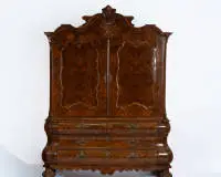 Cabinet baroque hollandais, dit Kabinetkast, Pays-Bas, vers 1750-1770, plaqué de noyer sur chêne, corps à deux portes avec couronnement galbé et cartouche sculpté sur base bombée, portes avec placage de ronce finement disposé et cadres profilés, partie inférieure avec quatre tiroirs sur trois niveaux et deux compartiments secrets dans les côtés bombés avec chacun quatre tiroirs, ceinture galbée sur pieds griffes sculptés, intérieur cabinet ouvert avec deux petits tiroirs supérieurs et trois tiro