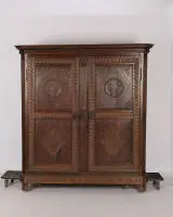 Armoire de mariage classique, datée 1823, chêne, corps à deux portes en construction à caissons avec pilastres biseautés, ces derniers avec cannelures sculptées, riches sculptures en relief avec bandeaux de méandres sur toutes les faces ainsi que motifs floraux et géométriques...