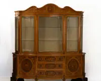 Commode met vitrine, in Franse stijl van het einde van de 18e eeuw, 1e helft 20e eeuw, onderkant rondom gebogen met bloemmotief marqueterie in diverse edelhoutsoorten, in het midden drie laden, links en rechts elk een deur, boven...