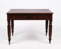 Bureau victorien, Angleterre, 2e moitié 19e s., acajou plaqué, corps d'écriture rectangulaire aux angles arrondis et deux tiroirs de ceinture, quatre pieds balustres octogonaux sur roulettes en laiton, plateau en cuir brun rouge avec dorure, 73.5 x 106 x 73 cm, plateau avec traces d'usage