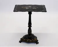 Table d'appoint victorienne, probablement Angleterre, 19e s., bois laqué noir, plateau galbé avec intarsia en nacre et nature morte florale peinte, plateau relevable sur fût balustre sur base trilobée, chacune avec peinture ornementale...