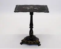 Table d'appoint victorienne, probablement Angleterre, 19e s., bois laqué noir, plateau galbé avec intarsia en nacre et nature morte florale peinte, plateau relevable sur fût balustre sur base trilobée, chacune avec peinture ornementale...