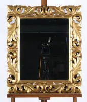 Miroir mural de style baroque italien, probablement 20e s., bois sculpté ajouré et doré, décor de feuilles d'acanthe volutées, verre miroir facetté, env. 51 x 40 cm