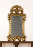 Miroir rococo, cadre doré sur fond rouge en forme de rocaille galbée avec feuilles de hêtre en relief dans le cartouche ajouré, 59 x 30 cm