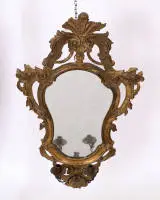 Miroir rococo avec bras de lumière, Italie, vers 1765, cadre en bois sculpté et riche décor rocaille ajouré, de la base naît un bras de lumière à deux feux en fer avec feuillage et fleur centrale, 83 x 53 cm, restaurations...