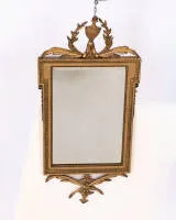 Spiegel im Stil Louis XVI, 18. oder 19. Jh., der Rahmen goldbronziert und bekrönt von einer Ziervase im Lorbeerkranz, facettiertes Glas, 87 x 41 cm, Restaurierungen