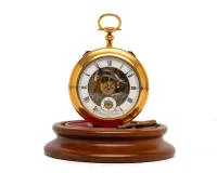 Les Freres Vuilleumier, Switzerland, travel clock in the form of a pocket watch, No. 109, gilded brass case, white numeral ring with Roman indices around skeletonized movement view, blued hands, repetition and alarm function each via slide controls