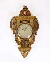 Классицистические настенные часы, Швеция, конец 18 в., подписаны Joh. Nyberg Stockholm, корпус вырезан из дерева и позолочен с богатым растительным декором, увенчан коронованным портретным медальоном королевы Фредерики Шведской, белый...