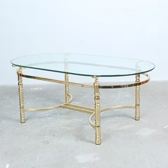 Coffee table with brass-trimmed metal frame and decorative column legs.