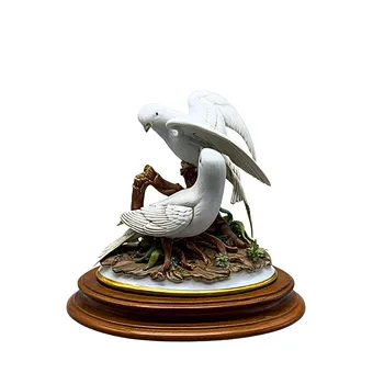 MANUFACTURE CARPIE. SCULPTURE EN PORCELAINE BISCUIT DE DEUX COLOMBES BLANCHES SUR UNE BRANCHE.