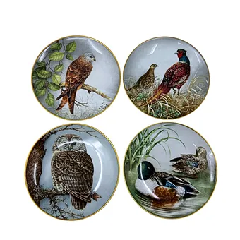 FRANKLIN MINT. QUATRE ASSIETTES DE COLLECTION EN PORCELAINE AVEC MOTIFS ANIMAUX ET LISERÉ DORÉ.