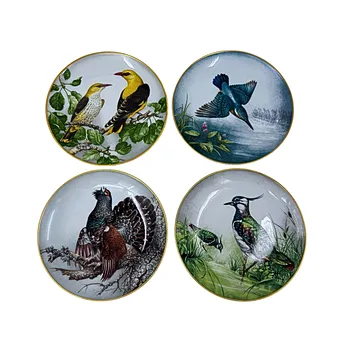 FRANKLIN MINT. QUATRE ASSIETTES DE COLLECTION EN PORCELAINE AVEC DIFFÉRENTS MOTIFS ANIMAUX ET LISERÉ DORÉ.