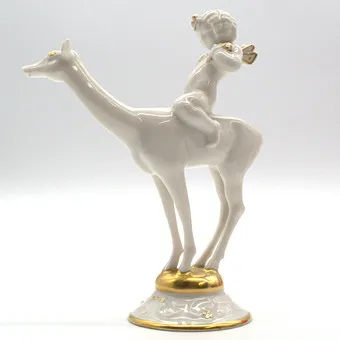 KARL TUTTER. FOR HUTSCHENREUTHER "IDYLL" PUTTO RIDING A DEER, GOLD DETAILS, ART DECO, GERMANY.