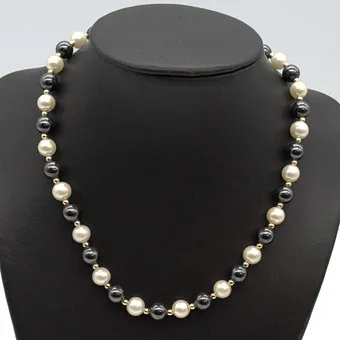 Imitation pearl necklace, black, white, gold-plated spacers, circa 1950, approx. 41 cm.