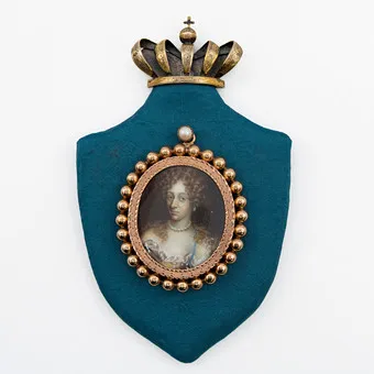 ANDREAS THORNBORG (1730-1780). CHARLOTTE AMALIE VON HESSEN-KASSEL (1650–1714), REINE DE DANEMARK ET DE NORVÈGE, MINIATURE (TEMPERA SUR PLAQUE), MONTURE MÉDAILLON DORÉE, MONTÉE SUR PLAQUE EN FORME DE BOUCLIER, COURONNE EN ARGENT DORÉ, 17E–18E SIÈCLE.