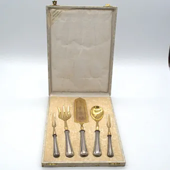 A. LOHNSTEIN. WORMS, FOURNISSEUR DE LA COUR, SERVICE DE DÉCOUPE ANTIQUE, MANCHES EN ARGENT 800, DENTS EN LAITON DORÉ, DANS BOÎTE D'ORIGINE VERS 1900.