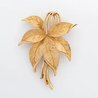 BROSZKA CROWN TRIFARI, FORMA DELIKATNIE WYGIĘTEGO LIŚCIA Z POZŁACANEGO, DELIKATNIE SZCZOTKOWANEGO TRIFANIUM, SYGNOWANA CROWN TRIFARI, LATA 1960.