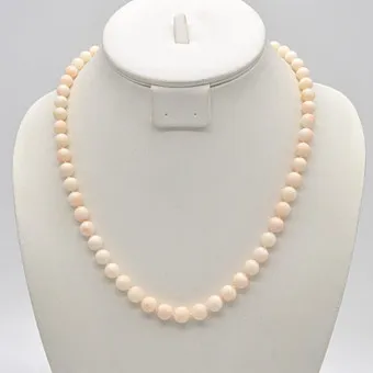 COLLIER DE PERLES EN CORAIL PEAU D'ANGE, PERLES RONDES, NOUÉES INDIVIDUELLEMENT, FERMOIR DORÉ, VERS 1950, LONGUEUR ENV. 51 CM