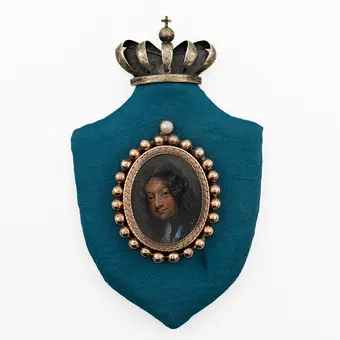 ANDREAS THORNBORG (1730-1780). KING CHRISTIAN V OF DENMARK. MINIATURE PAINTING (TEMPERA ON PANEL), GILT MEDALLION SETTING, MOUNTED ON SHIELD-SHAPED PANEL, GOLDEN SILVER CROWN, 17TH-18TH CENTURY.
