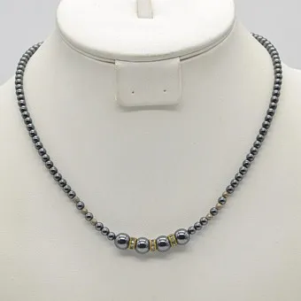 COLLIER DE PERLES D'HÉMATITE, 3 PERLES INTERCALAIRES DORÉES AVEC ZIRCONS, 6 PERLES INTERCALAIRES ARGENTÉES, FERMOIR DORÉ, ENV. 45 CM.