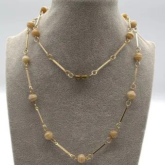 COLLIER EN VERRE DE MURANO, AVEC PERLES DE VERRE CRÈME, COULEUR AMBRE ET ÉLÉMENTS INTERMÉDIAIRES EN MÉTAL DORÉ VERS 1950 ENV. 60 CM.