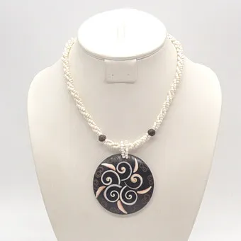 COLLIER D'OCÉANIE, PENDENTIF ROND EN NOIX DE COCO AVEC INCRUSTATIONS DE COQUILLAGE, CORDON AVEC PERLES DE VERRE, FIN 20E SIÈCLE, ENV. 44 CM.