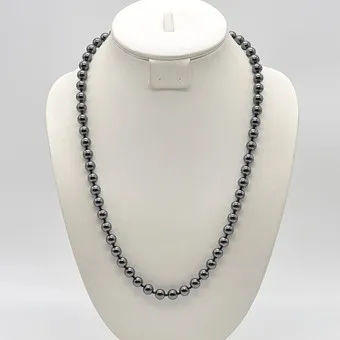 PERLENCOLLIER AUS HÄMATIT, POLIERTE PERLEN, VERGOLDETER VERSCHLUSS, UM 1950, CA. 62 CM.
