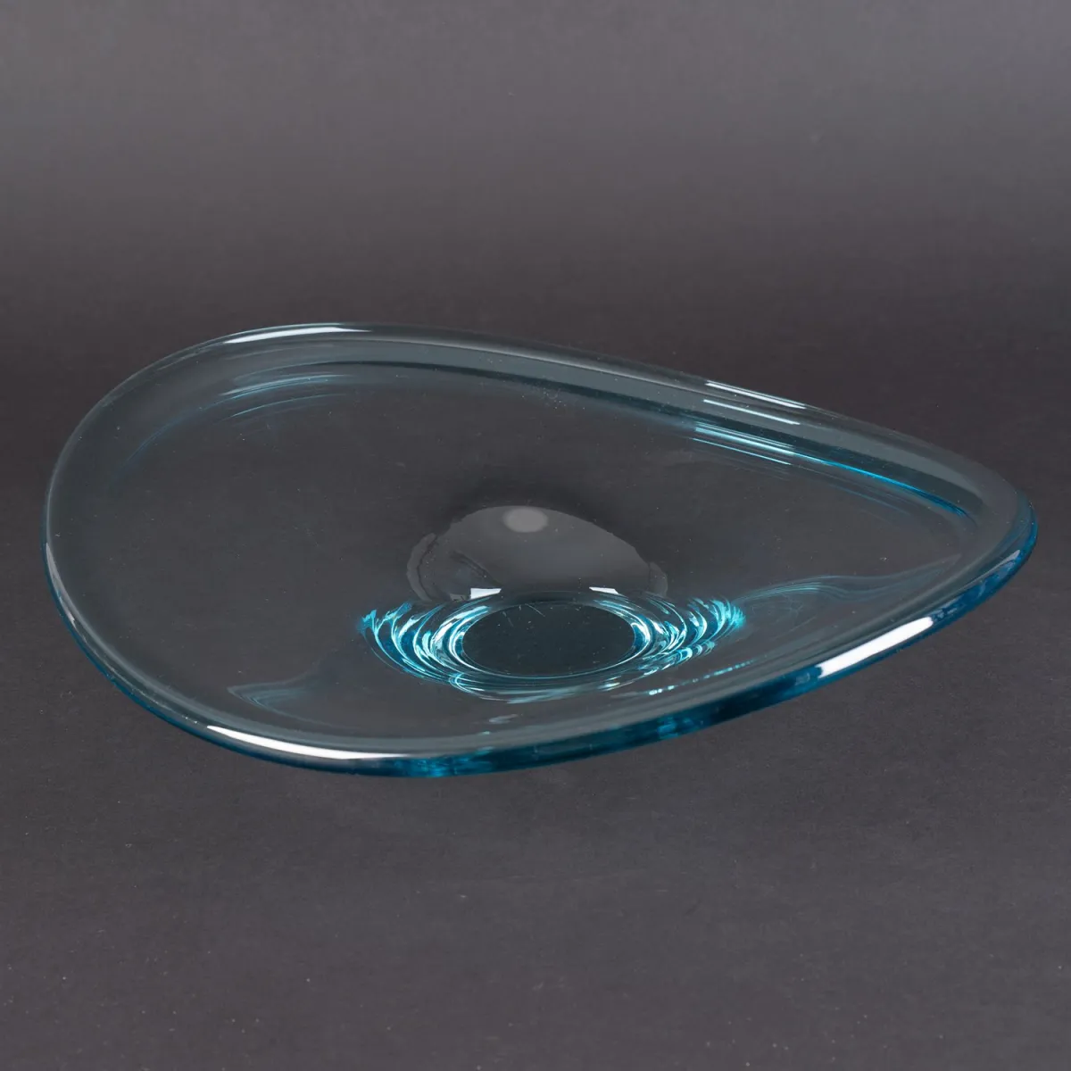 Ovale geschwungene Klarglasschale auf bläulichem Stand, Bodensignee geritzt: R. (Höhe ca. 9 cm, ca. 34 x 32 cm)