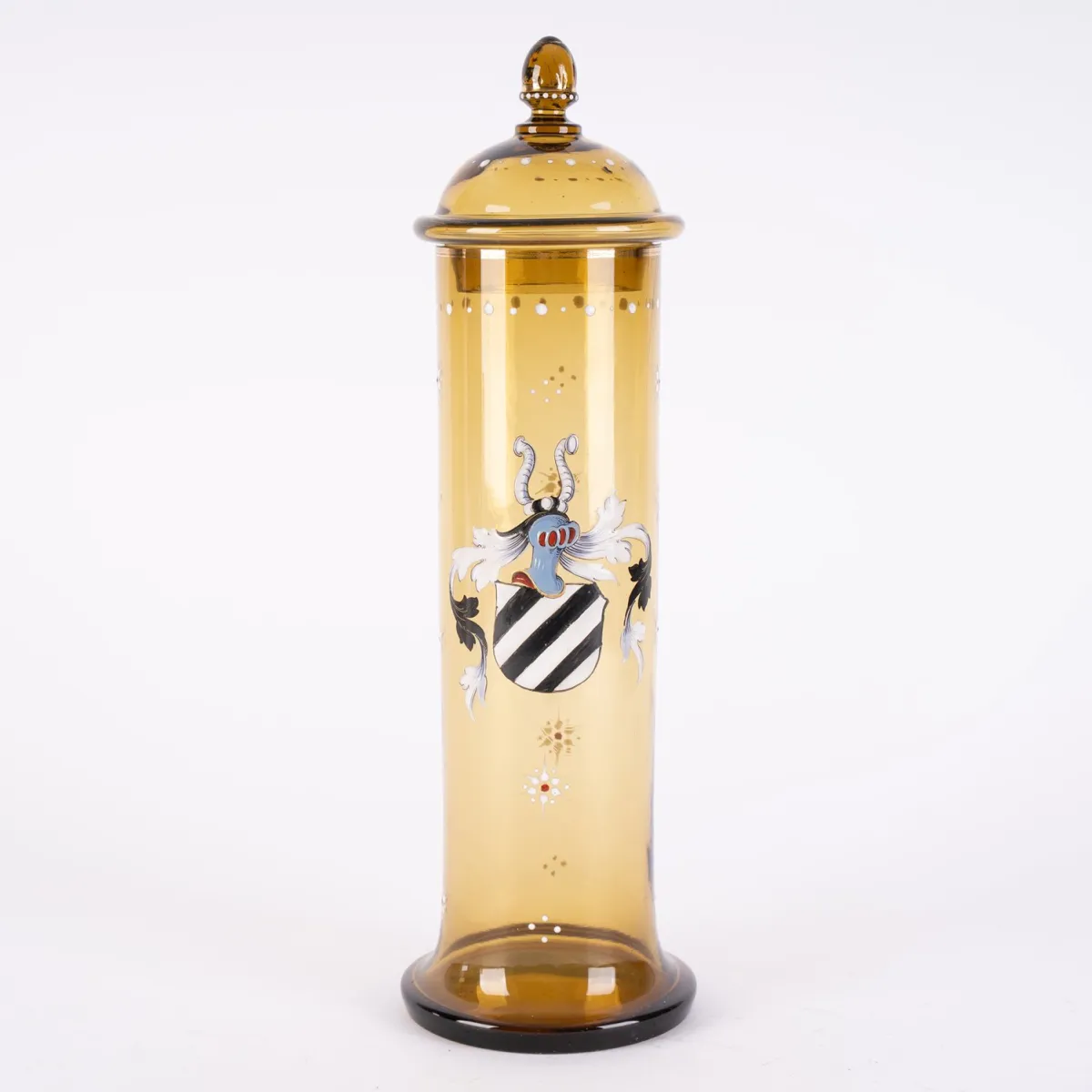 Cylindrical lidded vessel, honey-colored thick-walled glass vessel with polychrome enamel decor and heraldic ornament. Lid knob