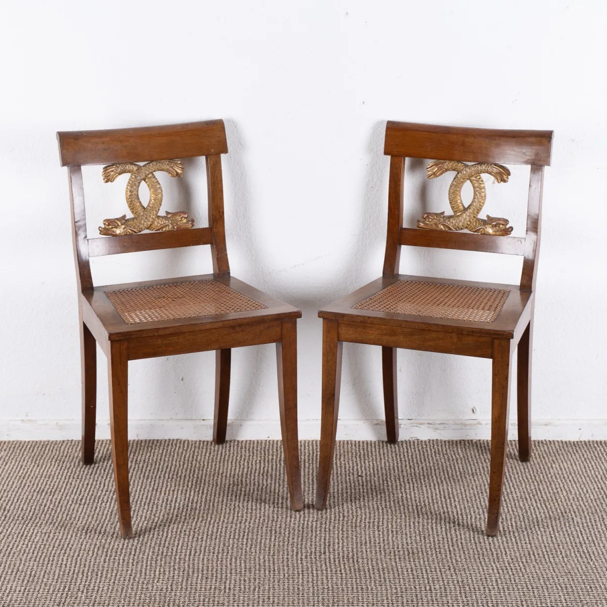 Pair of Empire / Biedermeier chairs, German circa 1820 / 30, walnut, the slightly curved backrest with sculpt…